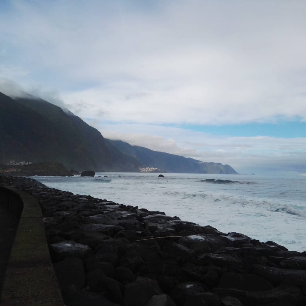 A large stormy wave crashing over rocks on Madeira